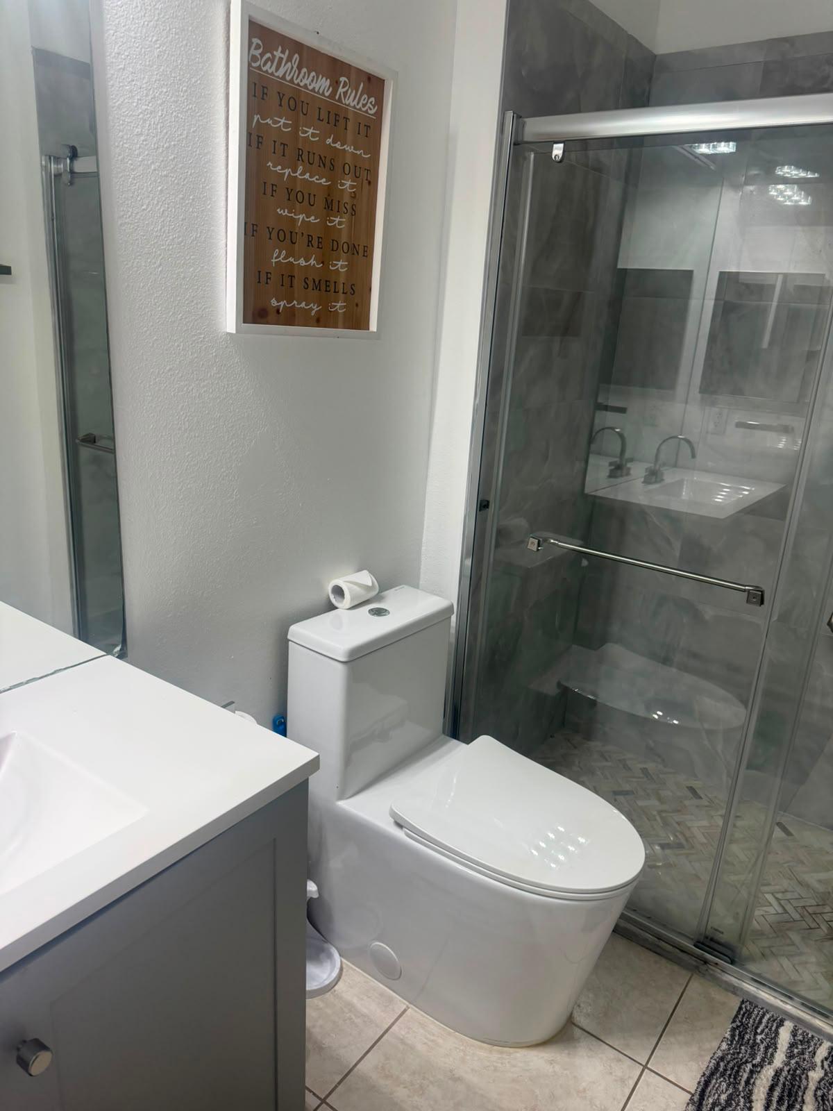 Guest bathroom with spotless glass shower and polished fixtures